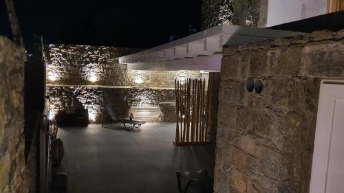 a dark room with a stone wall and a stove at Mykonos Double Luxury Mini Suites-With External Hot spa Adults only in Ano Mera
