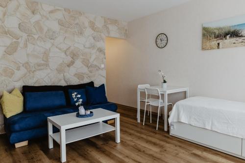 uma sala de estar com uma cama e um sofá azul em SK Apartments - Sandwood em Gelsenkirchen