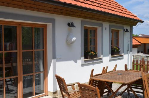 a white house with a wooden table and chairs at Apartmány Kojákovice - Třeboň in Jílovice