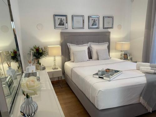 une chambre avec un grand lit blanc et une table dans l'établissement Casa Das Palmeiras, à Loulé