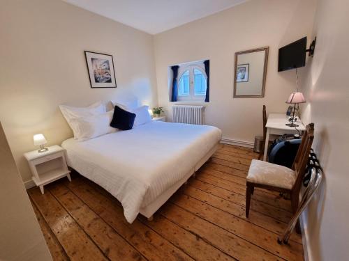 a bedroom with a large white bed and a chair at Le Rodin Bazas in Bazas