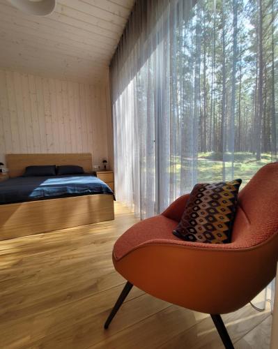 ein Schlafzimmer mit einem Bett, einem Stuhl und einem Fenster in der Unterkunft Beach House Trimpas 