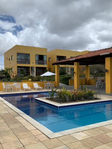 a resort with a swimming pool with tables and chairs at flat serra negra - bezerros - PE flat 007 - 009 in Bezerros