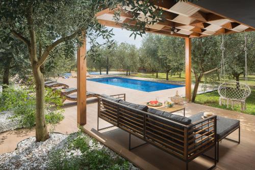 a patio with a bench and a swimming pool at Villa Stanzietta Novigrad for 10 at Olive orchard in Novigrad Istria