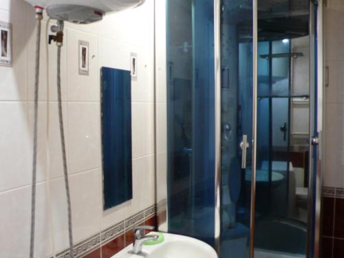 トムスクにあるApartment On Uchebnaya 7のバスルーム(シンク、鏡付きシャワー付)