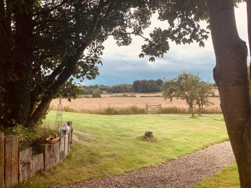a field of grass with a fence and a horse in it at Farmhouse studio near Shrewsbury in Shrewsbury