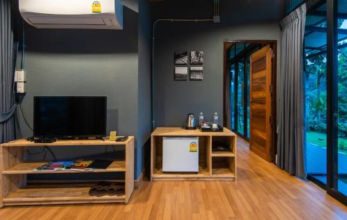 a living room with two tables and a television at Huaysompoi Valley Nan in Nan