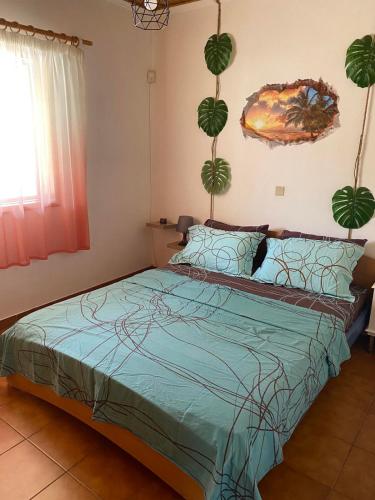 a bedroom with a bed with a green comforter at La casa de PortoRafti in Porto Rafti