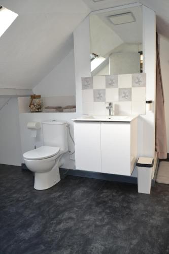 une salle de bain blanche avec des toilettes et un lavabo dans l'établissement Clos Caritan, à Perdreauville