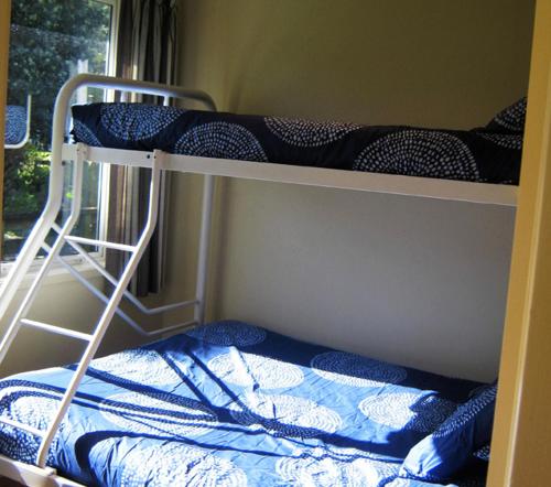 two bunk beds in a room with a window at Matauri Bay Holiday Park in Matauri Bay