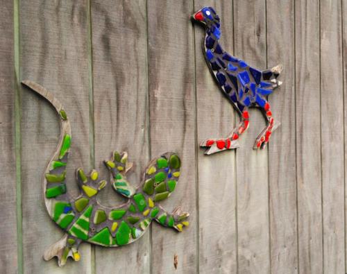 a lizard and a toy dinosaur on a wooden wall at Matauri Bay Holiday Park in Matauri Bay