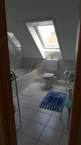 a bathroom with a skylight and a toilet and a bath tub at Gästezimmer von Annegret in Peine