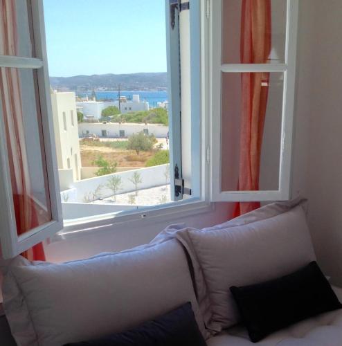 a couch in front of a window with a view at Anita Rooms & Suites Milos in Adamas