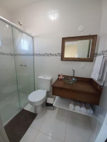 a bathroom with a toilet and a sink and a shower at Casa Ari Candiago Gramado in Gramado