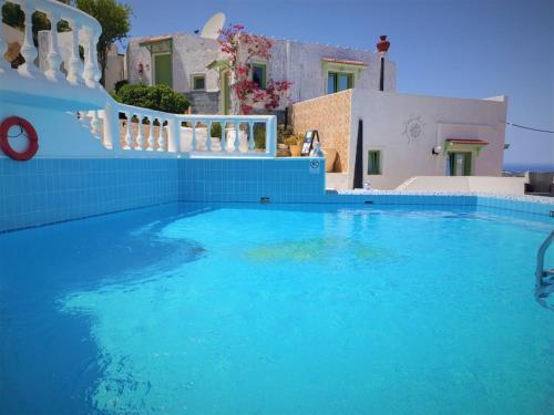 a swimming pool with blue water in front of a house at Room in Studio - Senior Citizen Suite in blue in Hersonissos