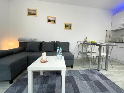 ein Wohnzimmer mit einem Sofa und einem Tisch in der Unterkunft Apartamenty Nadrzeczna24 in Tolkmicko