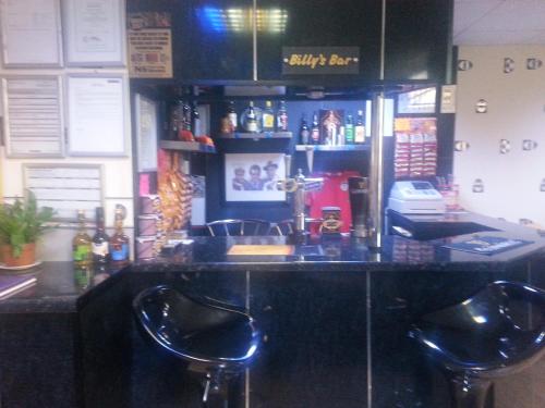 a bar with two bar stools in a restaurant at The Penrhyn in Blackpool