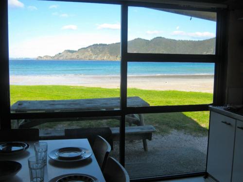 a view of the beach from a kitchen window at Matauri Bay Holiday Park in Matauri Bay