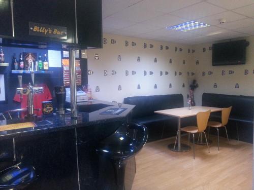 a restaurant with a counter and a table and chairs at The Penrhyn in Blackpool