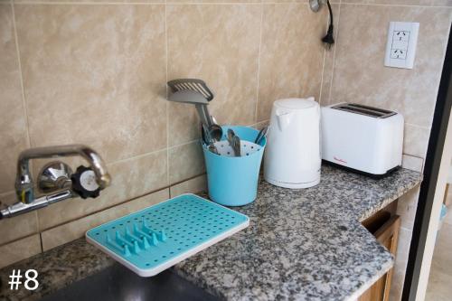 a kitchen counter with a sink with a strainer at Departamentos Rivadavia in Mendoza