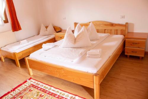 1 dormitorio con 2 camas y almohadas blancas en Pensiunea Mariana, en Ocna Şugatag
