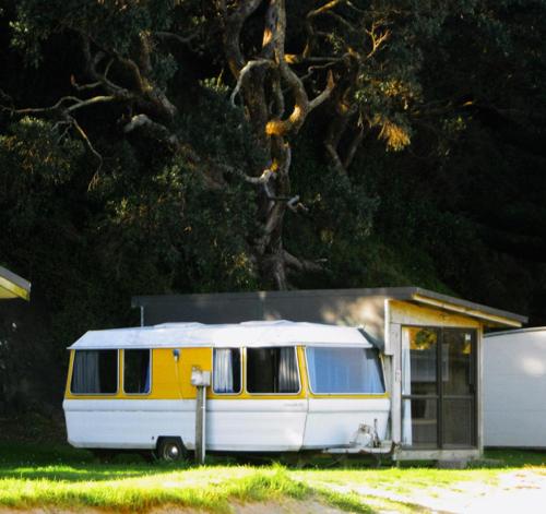 a yellow and white van parked in front of a house at Matauri Bay Holiday Park in Matauri Bay
