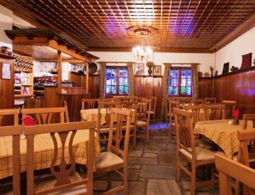 メツォヴォにあるHotel Bitouniのテーブルと椅子のあるレストラン、ダイニングルーム