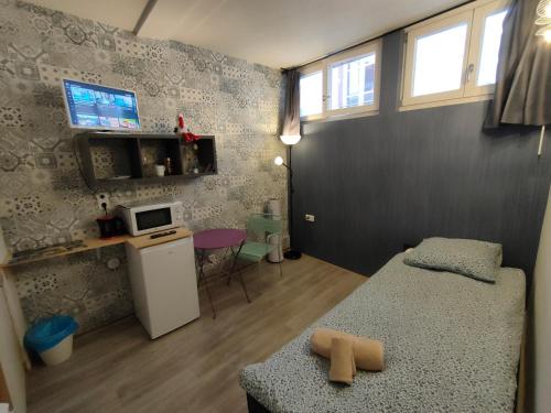 ein kleines Zimmer mit einem Bett und einer kleinen Küche in der Unterkunft La Provence Studio in Colmar