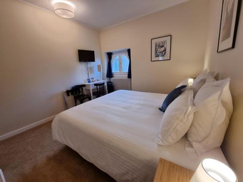 a bedroom with a bed with white sheets and pillows at Le Rodin Bazas in Bazas