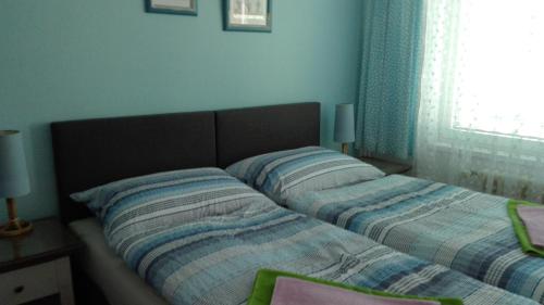 two beds in a bedroom with blue walls at Pension Beránek in Prague