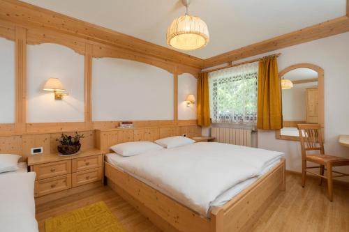 a bedroom with a large bed and a window at Villa Resi Apartments in Corvara in Badia