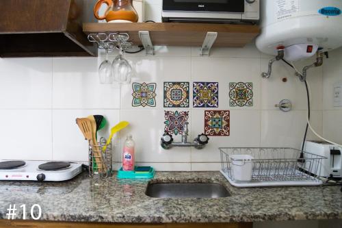 a kitchen counter with a sink and tiles on the wall at Departamentos Rivadavia in Mendoza