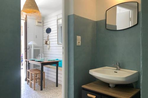 a bathroom with a sink and a table at Carrer del Sol in Sainte-Marie-la-Mer