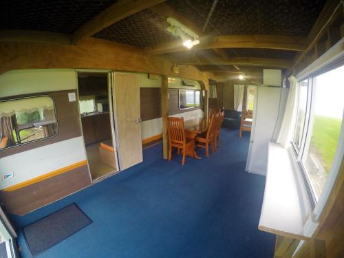 a train car with a table and chairs in it at Matauri Bay Holiday Park in Matauri Bay