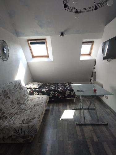 a room with two beds and a table and a couch at Studio roeze in Roézé-sur-Sarthe