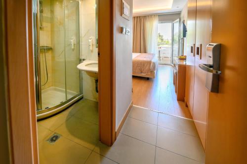 a room with a bathroom with a shower and a sink at Maritina Hotel in Kos Town