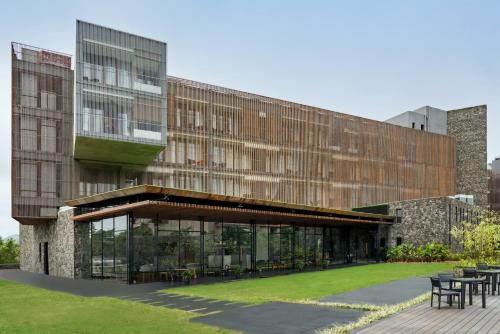 a building with tables and chairs in front of it at Radisson Resort and Spa Lonavala in Lonavala