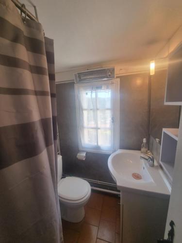 La salle de bains est pourvue de toilettes blanches et d'un lavabo. dans l'établissement MADE IN PROVENCE proche Cassis, à Les Barles
