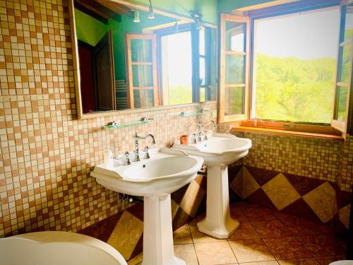 uma casa de banho com 2 lavatórios e um espelho em Farneto em Case Malva
