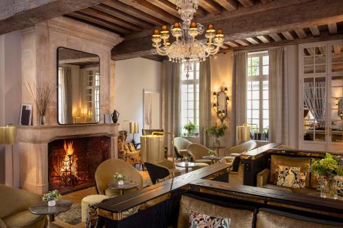 a living room with a fireplace and a chandelier at Hôtel D'Aubusson in Paris