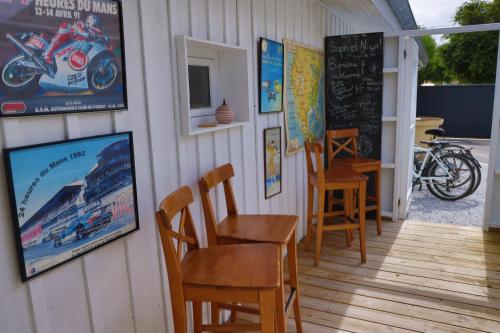 ein Restaurant mit Stühlen und einer Tafel an der Wand in der Unterkunft les coquilles in Lanton