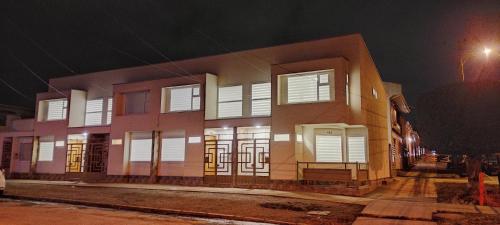 a building with white shuttered windows at night at Casa nueva, excelente ubicación in Punta Arenas