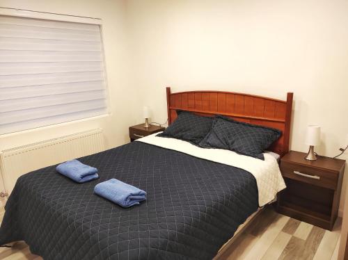 a bedroom with a bed with two blue towels on it at Casa nueva, excelente ubicación in Punta Arenas