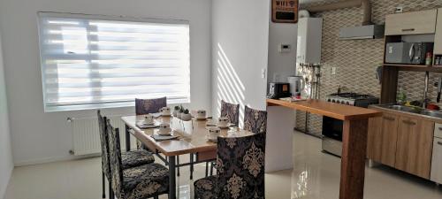 cocina con mesa, sillas y ventana en Casa nueva, excelente ubicación, en Punta Arenas