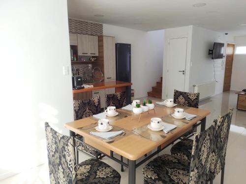 a dining room table with chairs and a kitchen at Casa nueva, excelente ubicación in Punta Arenas