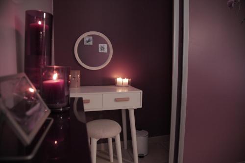 a bathroom with a table with two candles and a stool at Au Doux Repos in Lucbardez-et-Bargues
