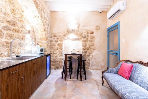 a kitchen with a sink and a couch in a room at Arabesque House in ‘Akko