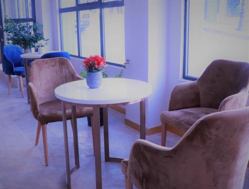 a table and two chairs and a vase with flowers on it at VANCII Hotel in Chefchaouene