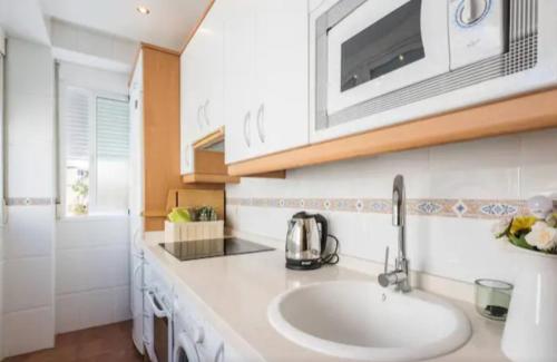 a kitchen with a sink and a microwave at Amazing City Center Apartment in Málaga