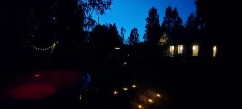 una vista nocturna de una casa con luces en la oscuridad en Brīvdienu māja ar Saunu, en Saulkrasti